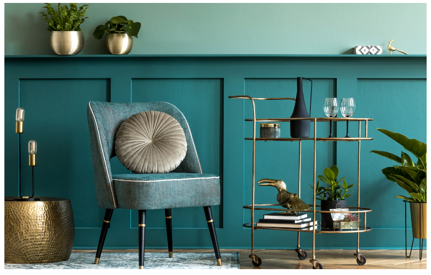 Modern teal living room with chair and plants.