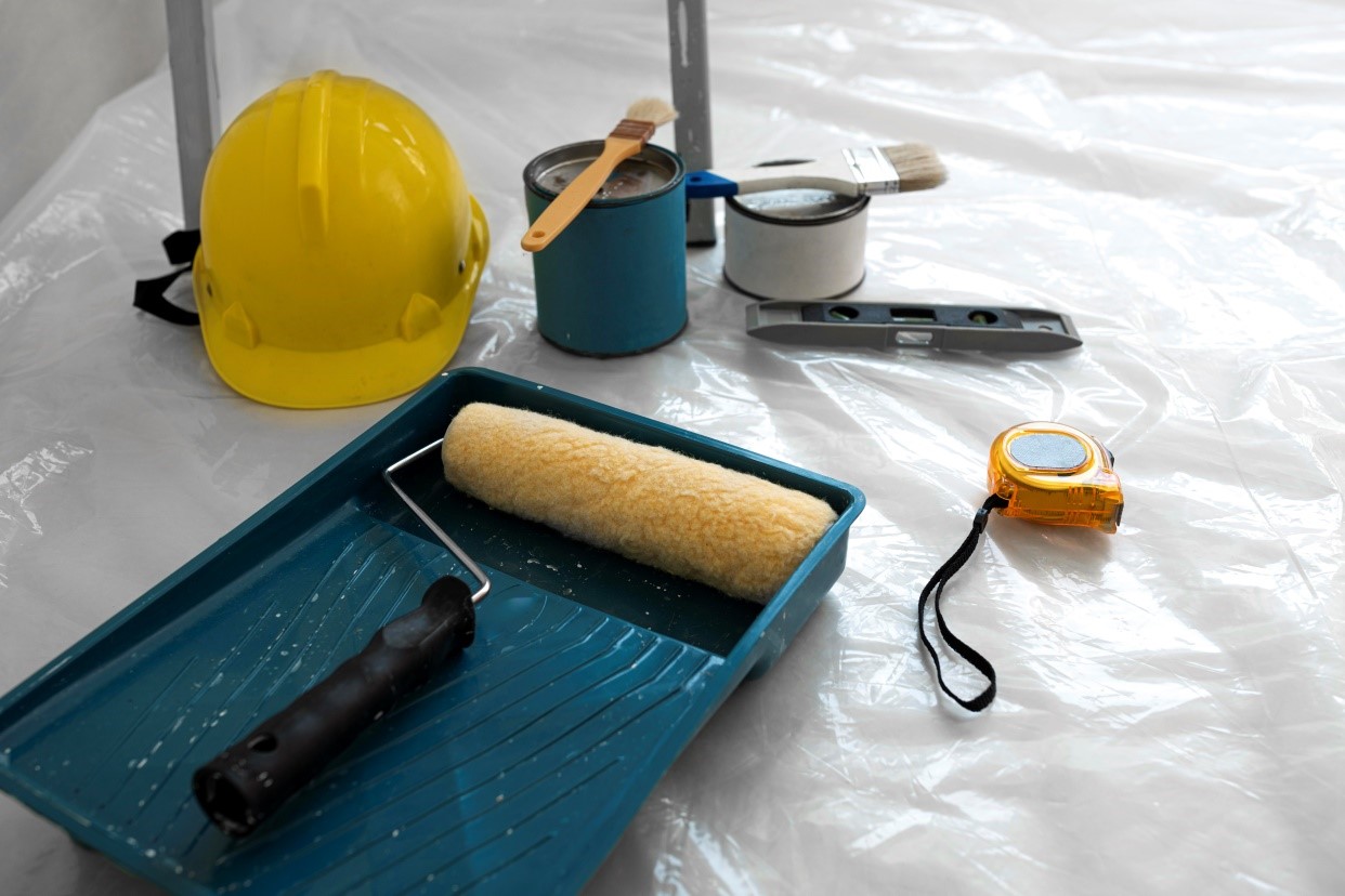 Set of painting and construction tools, including a hard hat, roller