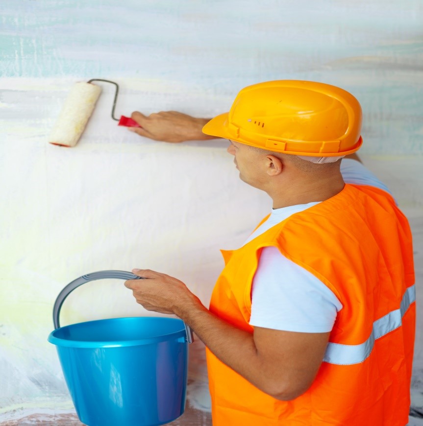 Worker painting a wall with a roller