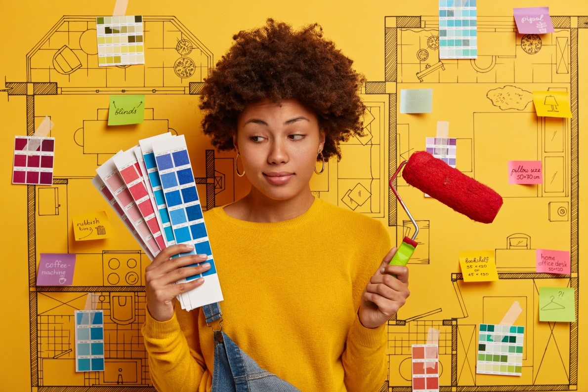 yellow sweater holds color swatches and a paint roller