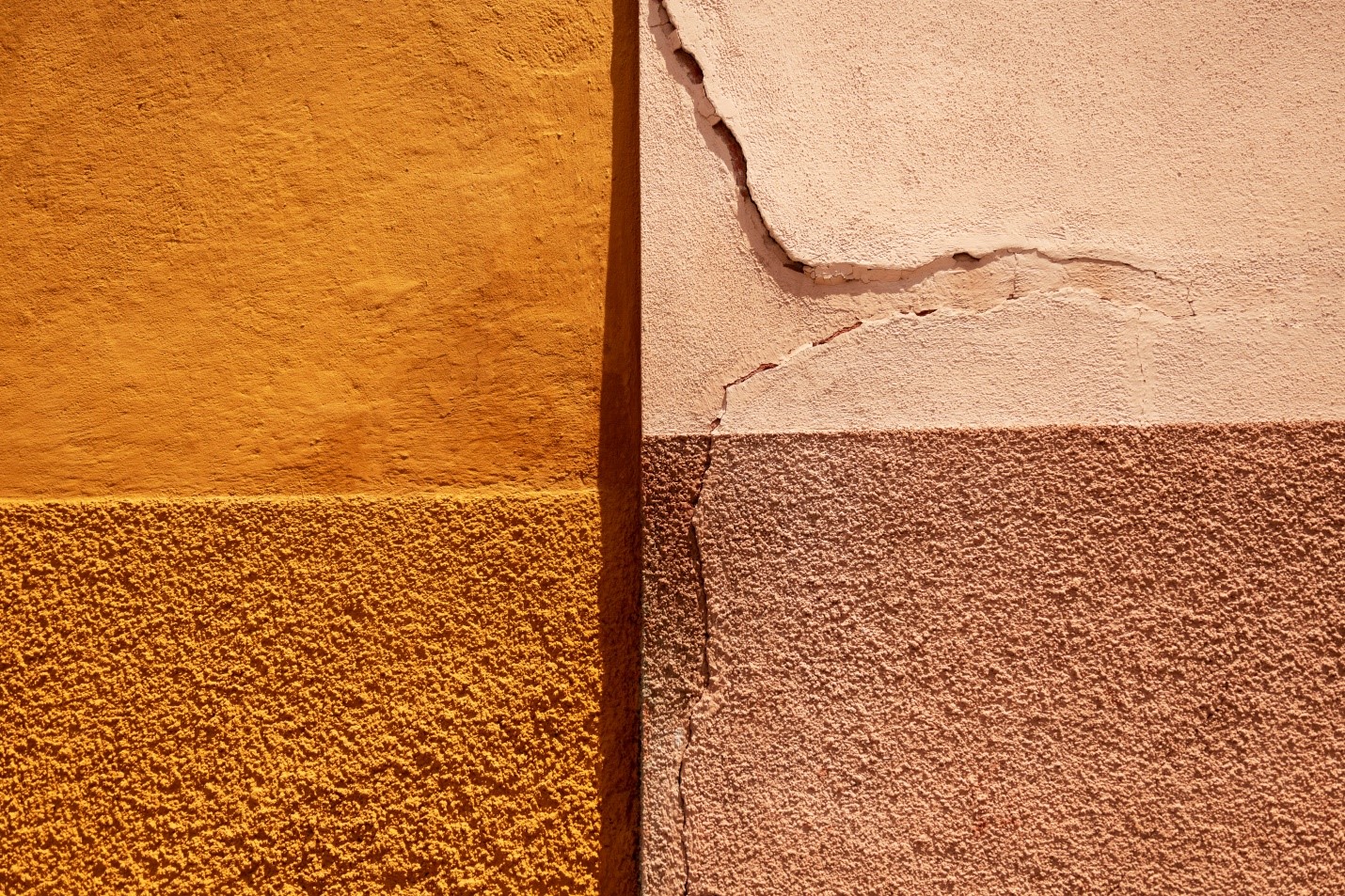 Close-up of a textured wall with two different shades of yellow and orange