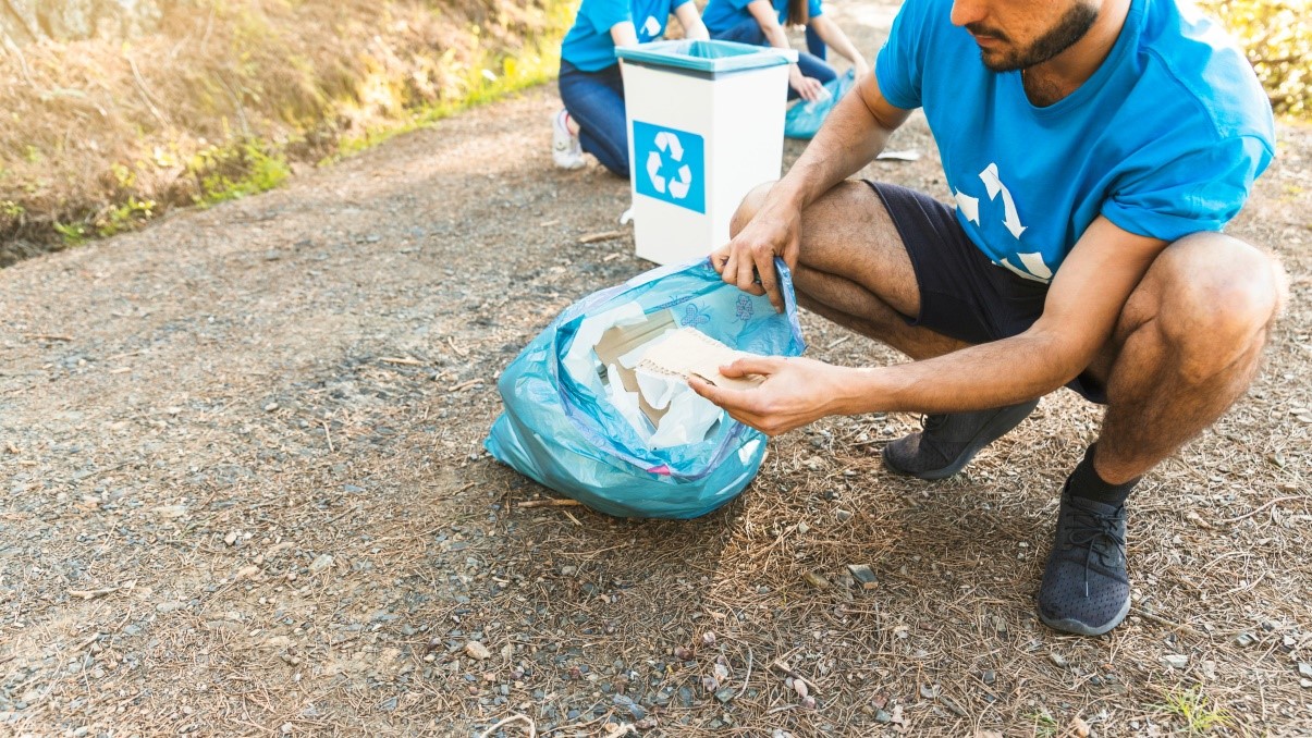 Person collecting recyclables during a community clean-up event